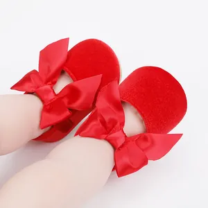 Detailopname van elegante rode fluwelen baby prinsessenschoenen met een grote satijnen strik