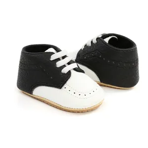 Close-up of black and white leather baby soft sole shoes with perforated details