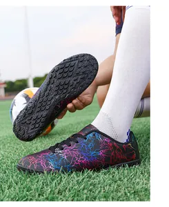 Gros plan sur la semelle de chaussure de foot et motif éclair coloré sur le gazon