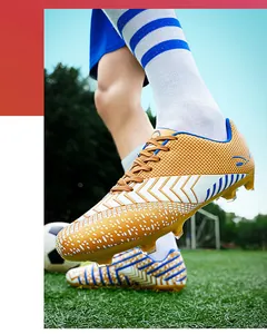 Vue détaillée des chaussures de football rayées jaune et blanc sur un terrain d'herbe