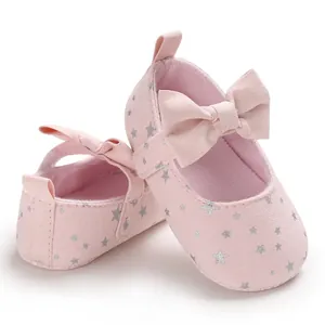 Nahaufnahme von rosa Baby-Prinzessinenschuhen mit silbernen Sternen und Schleifen