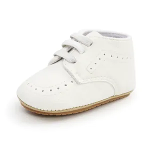 Side view of white PU leather baby pre-walker shoe with soft sole and brogue details