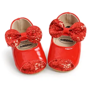 Sparkly red baby girl princess shoes featuring a large glitter bow and soft soles