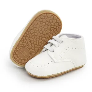 Detail view of white soft-soled PU baby sneakers with non-slip textured outer sole