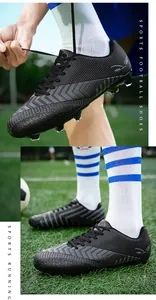 Détail de chaussures de football noires à crampons pour hommes sur terrain synthétique.