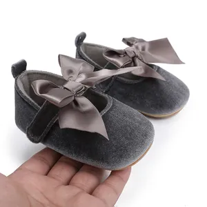 Detailweergave van grijze fluwelen baby prinsessenschoenen met een grote satijnen strik