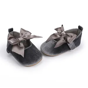 Detailopname van grijze fluwelen baby prinsessenschoenen met sierlijke satijnen strikken