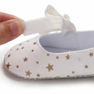 Nahaufnahme weißer Baby-Prinzessinnenschuh mit Klettverschluss und goldenen Sternen