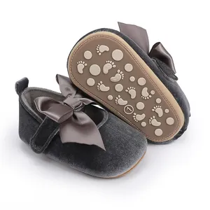 Detail van grijze fluwelen babyschoentjes met satijnen strik en zachte antislipzool