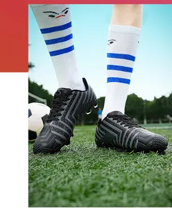 Gros plan sur des crampons de football noirs pour hommes sur un terrain synthétique