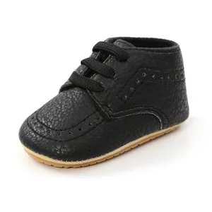 Close-up of black PU leather baby walking shoe with soft sole and brogue details.