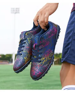 Gros plan de chaussures de football durables avec motif éclair multicolore sur un terrain