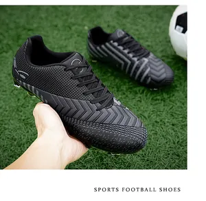 Vue détaillée des chaussures de foot noires avec motifs à chevrons et crampons moulés