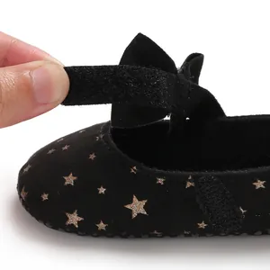 Detailaufnahme von Babyschuhen mit goldenem Sternenmuster und Klettverschluss