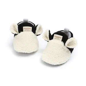 Close-up detail of plush baby walker shoes with cute cartoon ears in black and white
