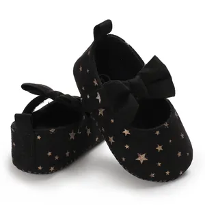 Schwarze Baby-Prinzessinenschuhe mit goldenen Sternenmustern und süßer Schleife.