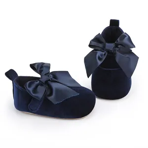 Gedetailleerde close-up van marineblauwe fluwelen babyschoentjes met satijnen strikken