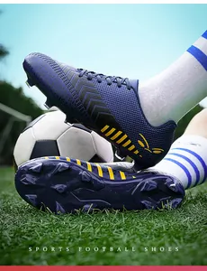 Gros plan de chaussures de football professionnelles violettes et jaunes sur gazon artificiel