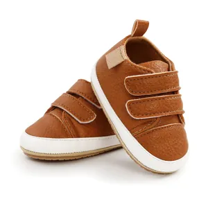 Detailed view of brown PU leather baby walking shoes with white soles and velcro straps