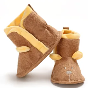 Gros plan de bottines pour bébé en peluche marron avec broderie d'animal mignon