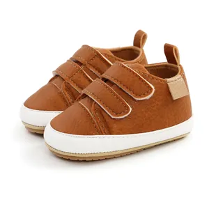 Brown PU leather baby walking shoes with dual velcro straps and soft white rubber soles.