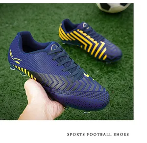 Vue détaillée des chaussures de football professionnelles violettes et jaunes sur gazon