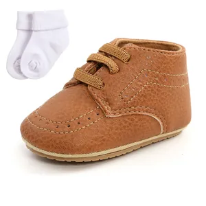 Detailed view of brown faux leather baby walking shoes with soft soles and socks