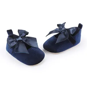 Gedetailleerd beeld van blauwe fluwelen babyschoentjes met een grote decoratieve satijnen strik