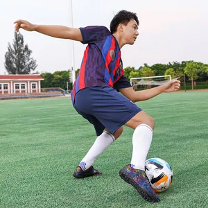 Crampons de football pour hommes avec motif graffiti coloré sur terrain de gazon vert