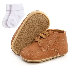 Close-up of brown PU leather baby walking shoes with soft non-slip sole and white socks