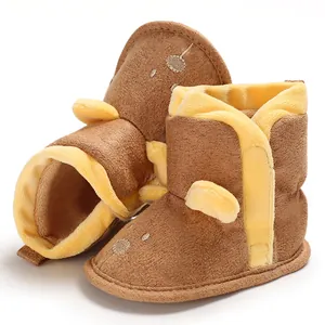 Gros plan sur des bottes d'hiver pour bébé en polaire marron et jaune avec oreilles