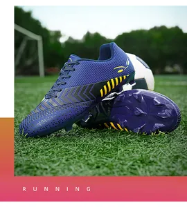 Détail de chaussures de foot bleu et jaune sur gazon artificiel pour enfants et hommes