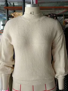 Close-up view of a cream-colored round neck knit sweater displayed on a dress form mannequin