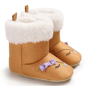 Détail de bottes d'hiver marron pour bébé avec doublure blanche et nœud violet