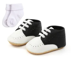 Black and white soft-sole baby walking shoes with matching white socks for toddlers