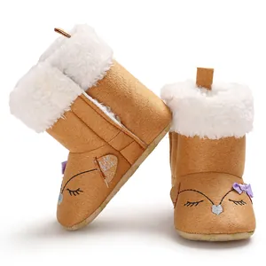 Gros plan sur la bordure en fausse fourrure blanche et la broderie renard des bottes bébé