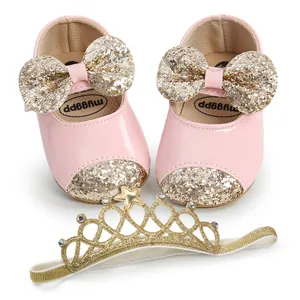 Detail of pink baby princess shoes with gold glitter bow and matching crown headband