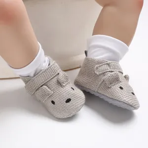 Nahaufnahme von grauen Strick-Babyschuhen mit süßem Maus-Design und weichen Sohlen.