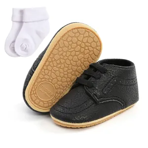 Detailed view of black soft sole baby shoes and white socks set for infants