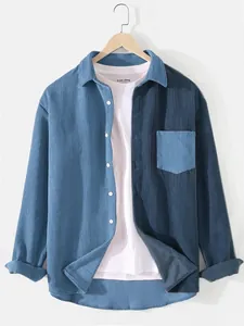 Détail d'une chemise en velours côtelé bleu bicolore avec poche de poitrine contrastée.