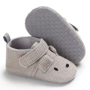 Detaillierte Ansicht grauer gestrickter Babyschuhe mit weichen rutschfesten Sohlen.