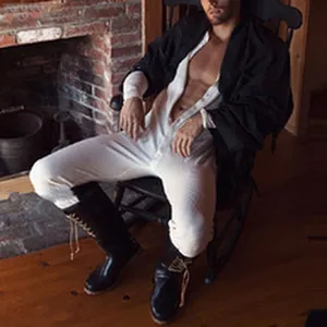 Foto de estilo de vida de un modelo con mono blanco de botones y botas negras altas