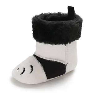 Détail de bottes d'hiver en peluche noir et blanc pour bébé avec semelle souple et chaude