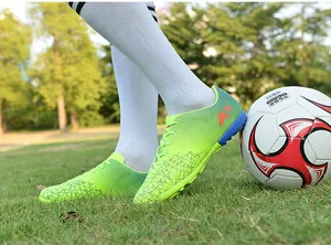 Close-up of youth soccer turf shoes with AG studs on artificial grass field