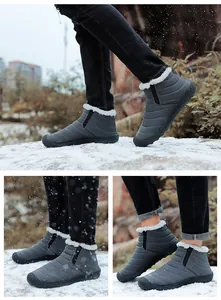 Warme graue gesteppte Winterschuhe mit weißem Kunstfellfutter in der Schneeszene