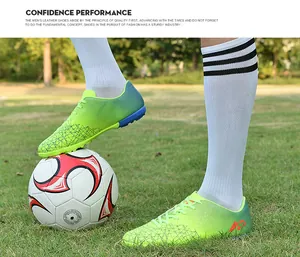 Close-up detail of vibrant green youth soccer shoes with TF studs on a grassy field