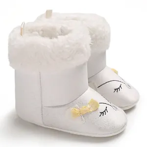 Vue détaillée de bottes d'hiver blanches pour bébé avec fourrure synthétique et nœud