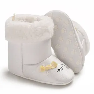 Vue latérale et de la semelle des bottes d'hiver blanches avec nœud jaune