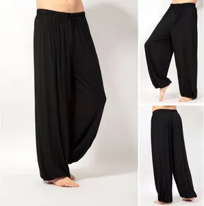 Vista detallada de pantalones de yoga negros sueltos para hombre con puños elásticos