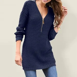Close-up of navy blue waffle-knit fabric and gold-tone V-neck zipper detail on sweater.